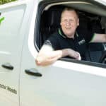 Oven valeting service vehicle with technician smiling inside.