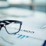 Business consultation with glasses on documents for franchise growth.