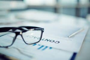Business consultation with glasses on documents for franchise growth.