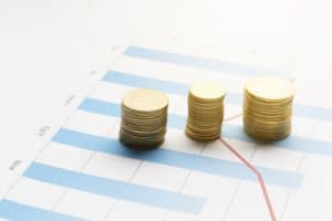 Stacked coins on financial chart showing franchise investment growth trends.